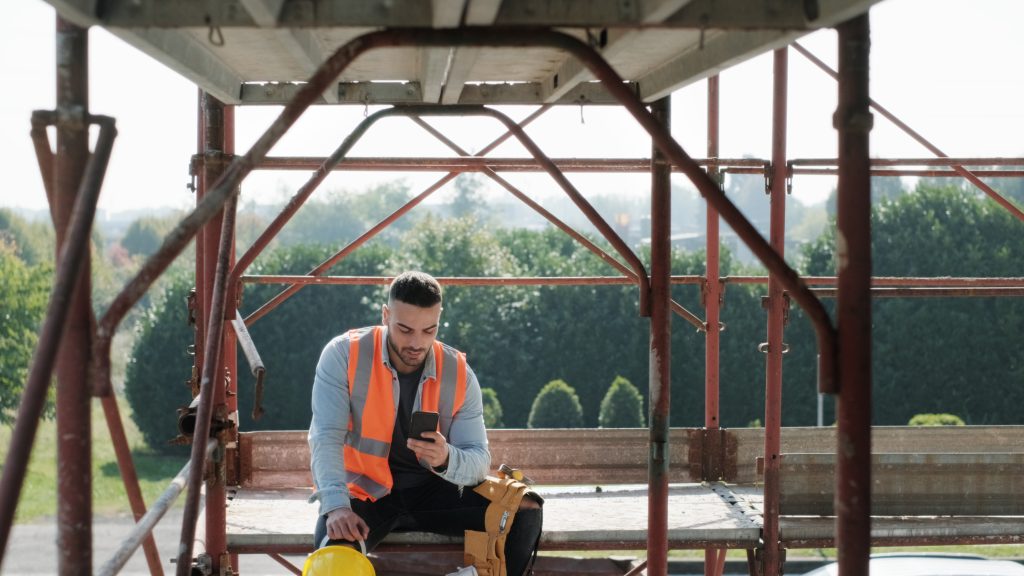 Construction worker using a smartphone to learn on the go.